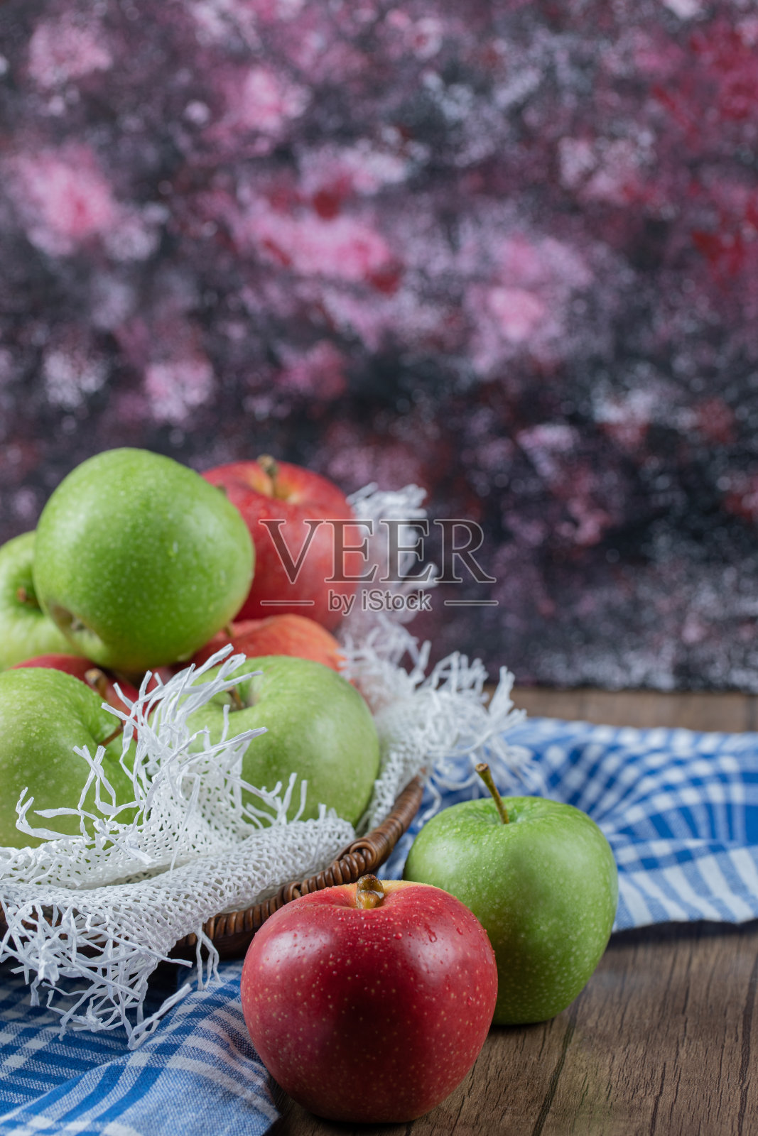 苹果装在一个篮子里，放在一块白粗麻布上照片摄影图片