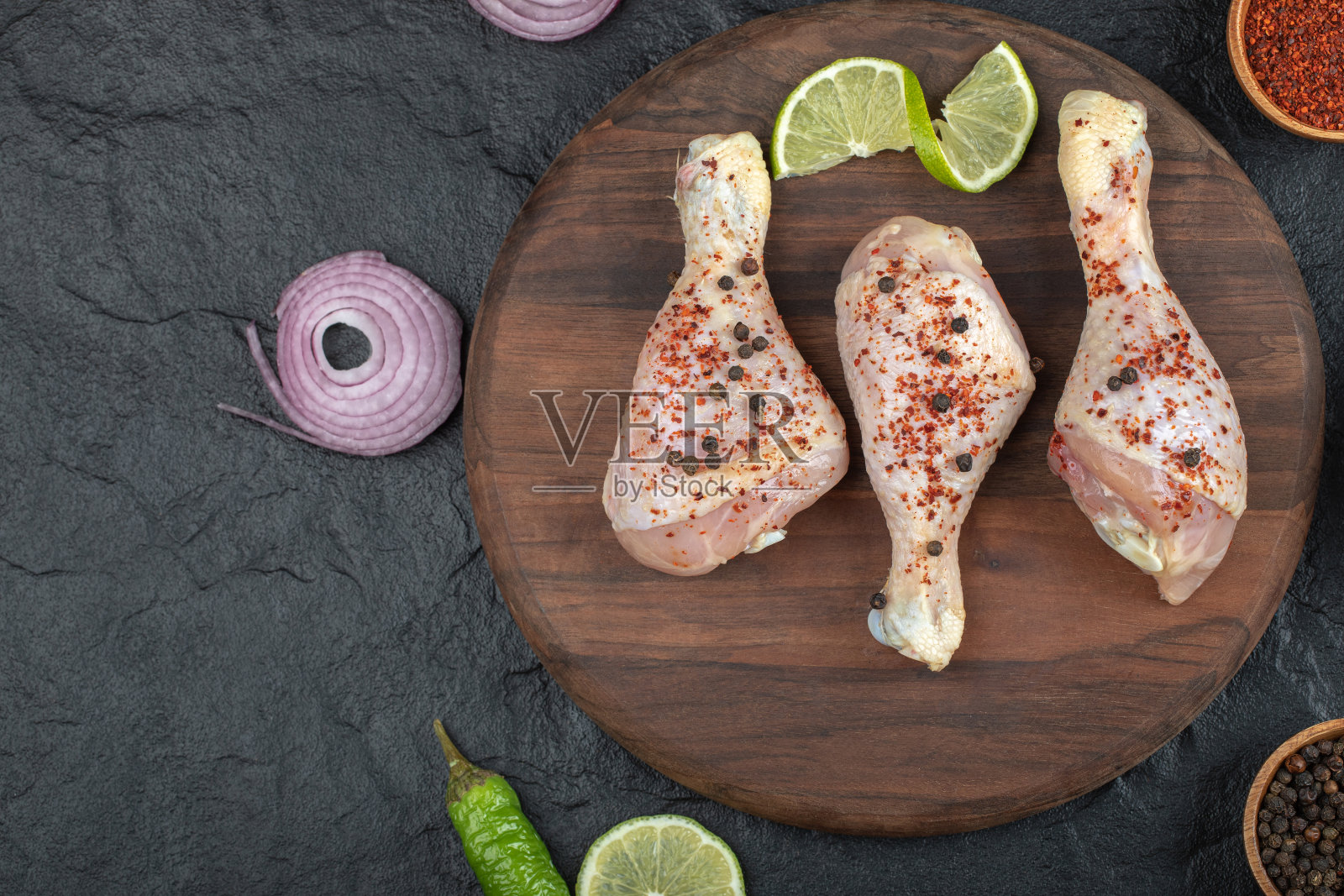 近距离的照片辣生鸡腿与石灰在木板上照片摄影图片