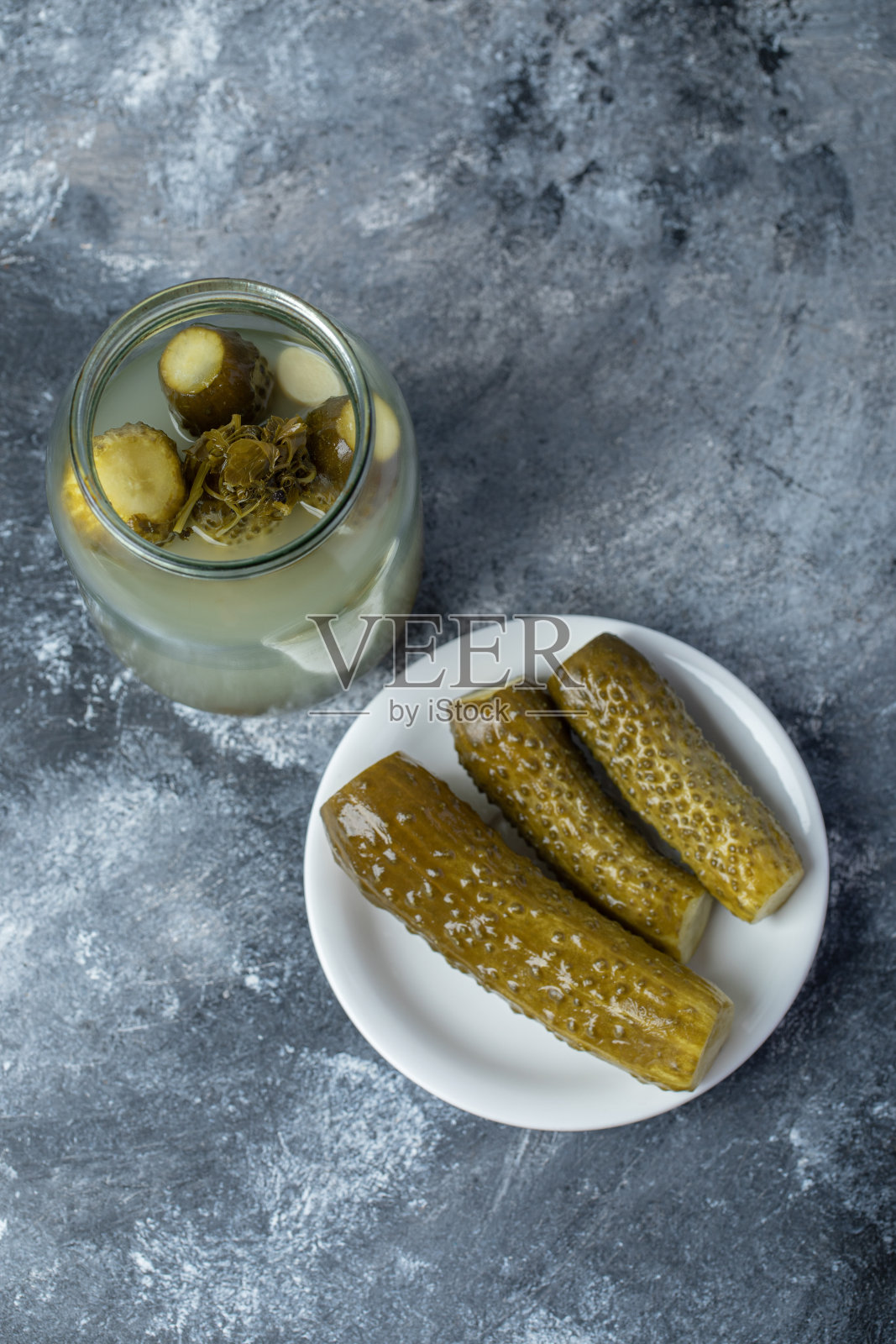 大理石背景上的玻璃罐里腌制的黄瓜照片摄影图片