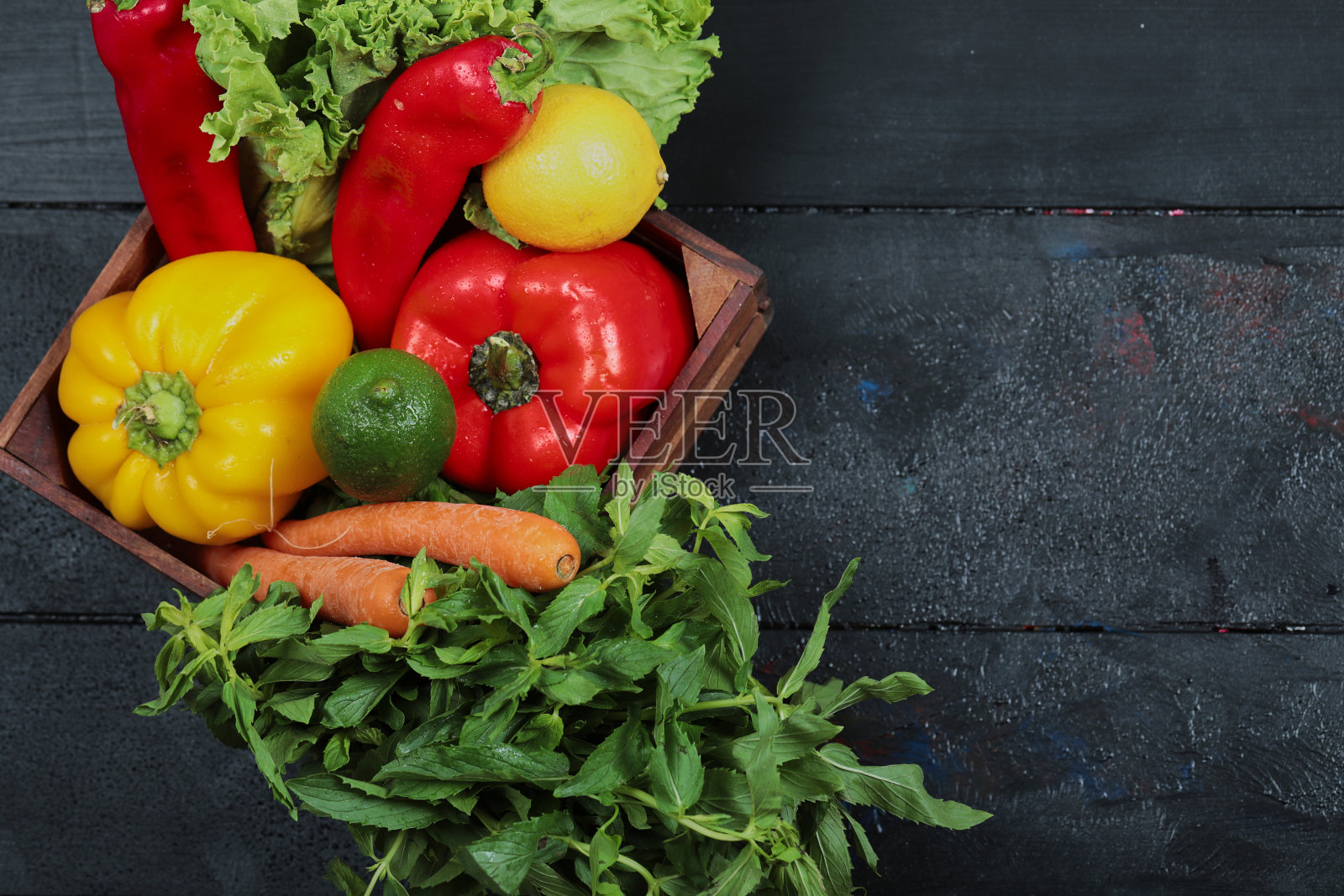 胡椒粉、生菜、胡萝卜、柠檬、青柠及薄荷装于木盒内照片摄影图片