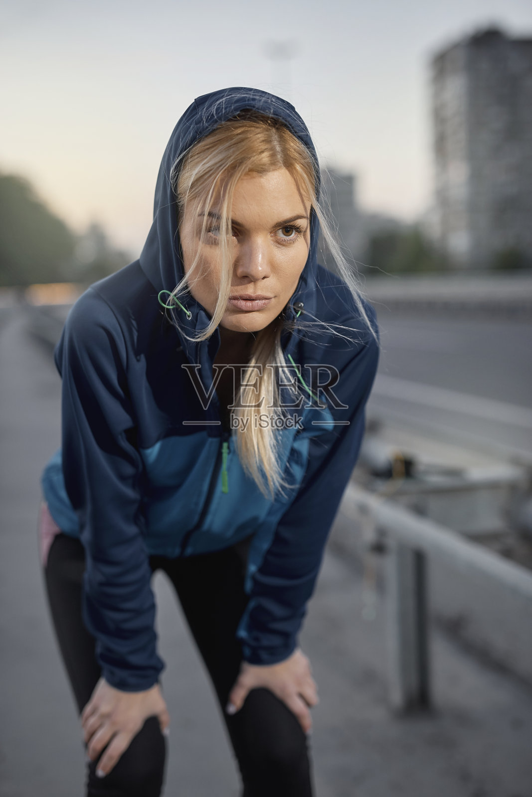 一位年轻美丽的女运动员正在休息身体。照片摄影图片