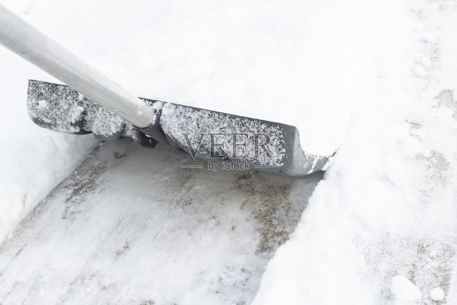 冬天用大铁铲清理积雪照片摄影图片