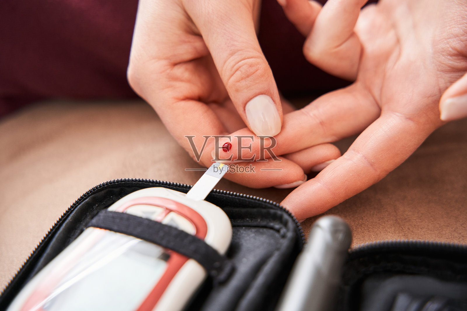 手持便携式电子血糖仪的妇女照片摄影图片