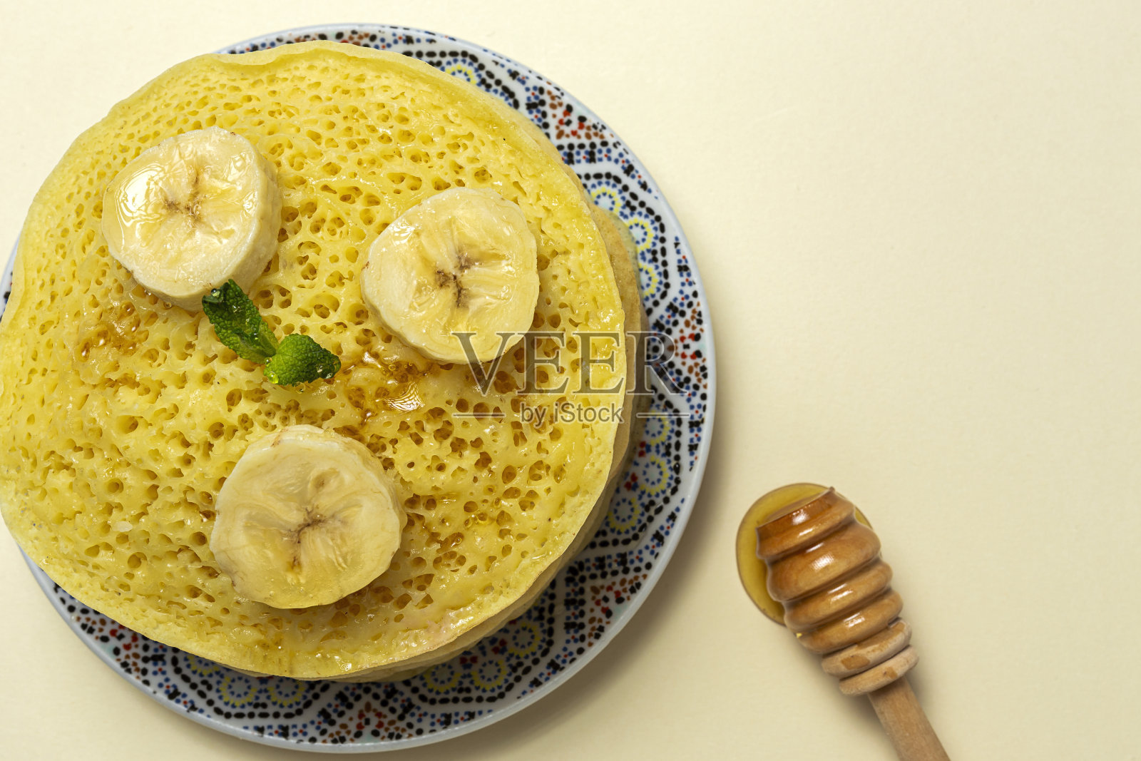 自制的传统摩洛哥baghrir配上蜂蜜，草莓和薄荷照片摄影图片