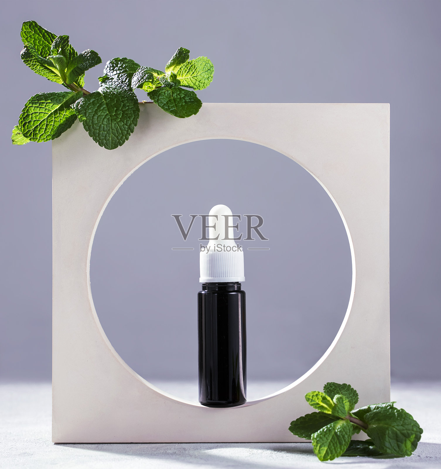 薄荷油在玻璃瓶与新鲜薄荷叶照片摄影图片