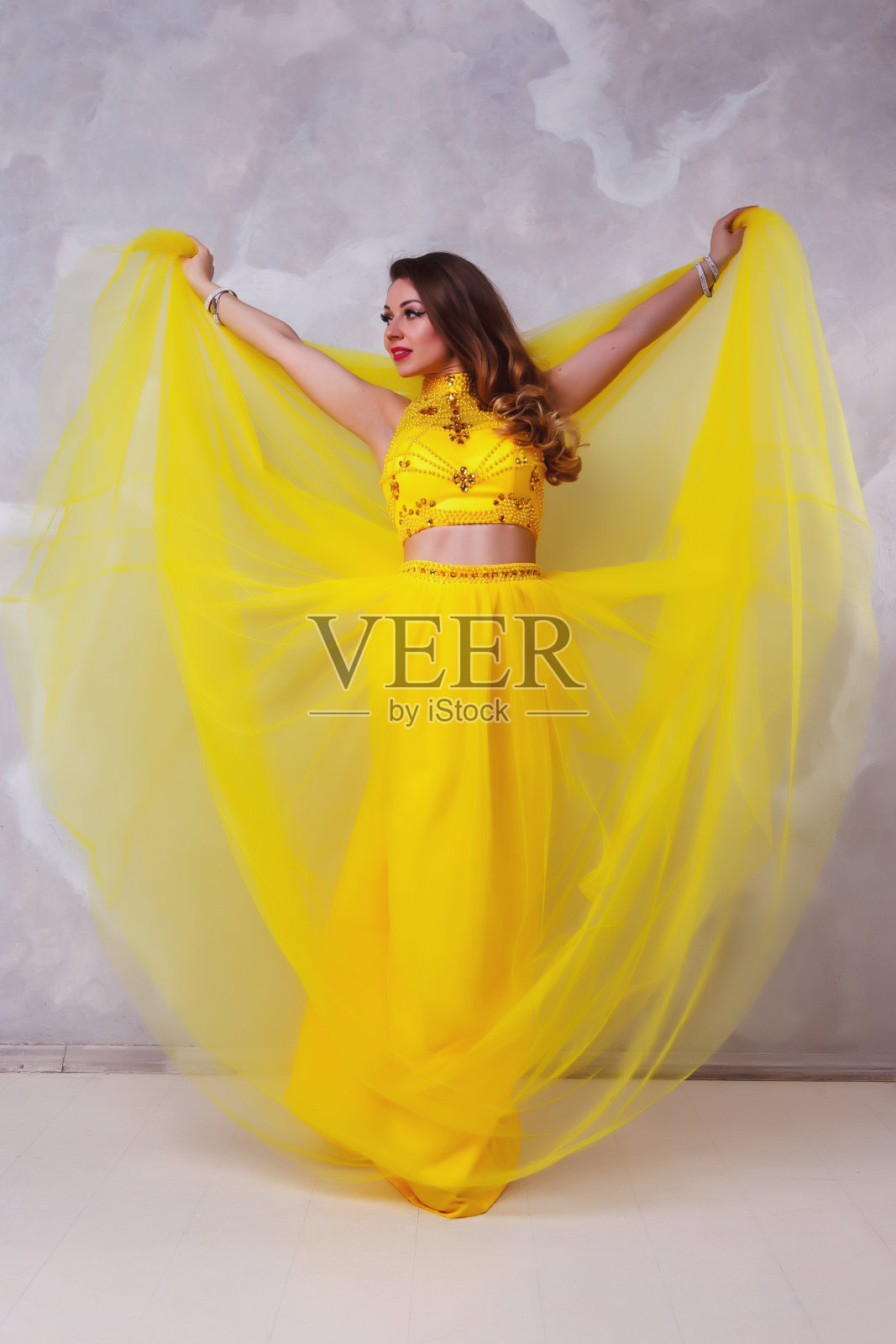 漂亮的女士在长舞台黄色连衣裙肖像纹理白色墙壁照片摄影图片