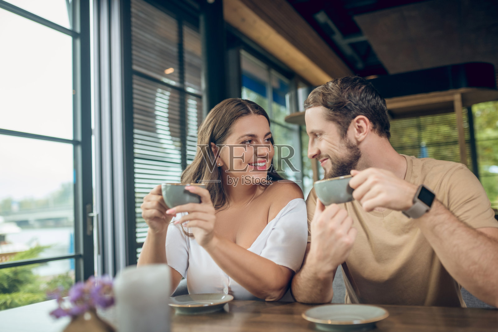 快乐的男人和女人在咖啡馆喝咖啡照片摄影图片
