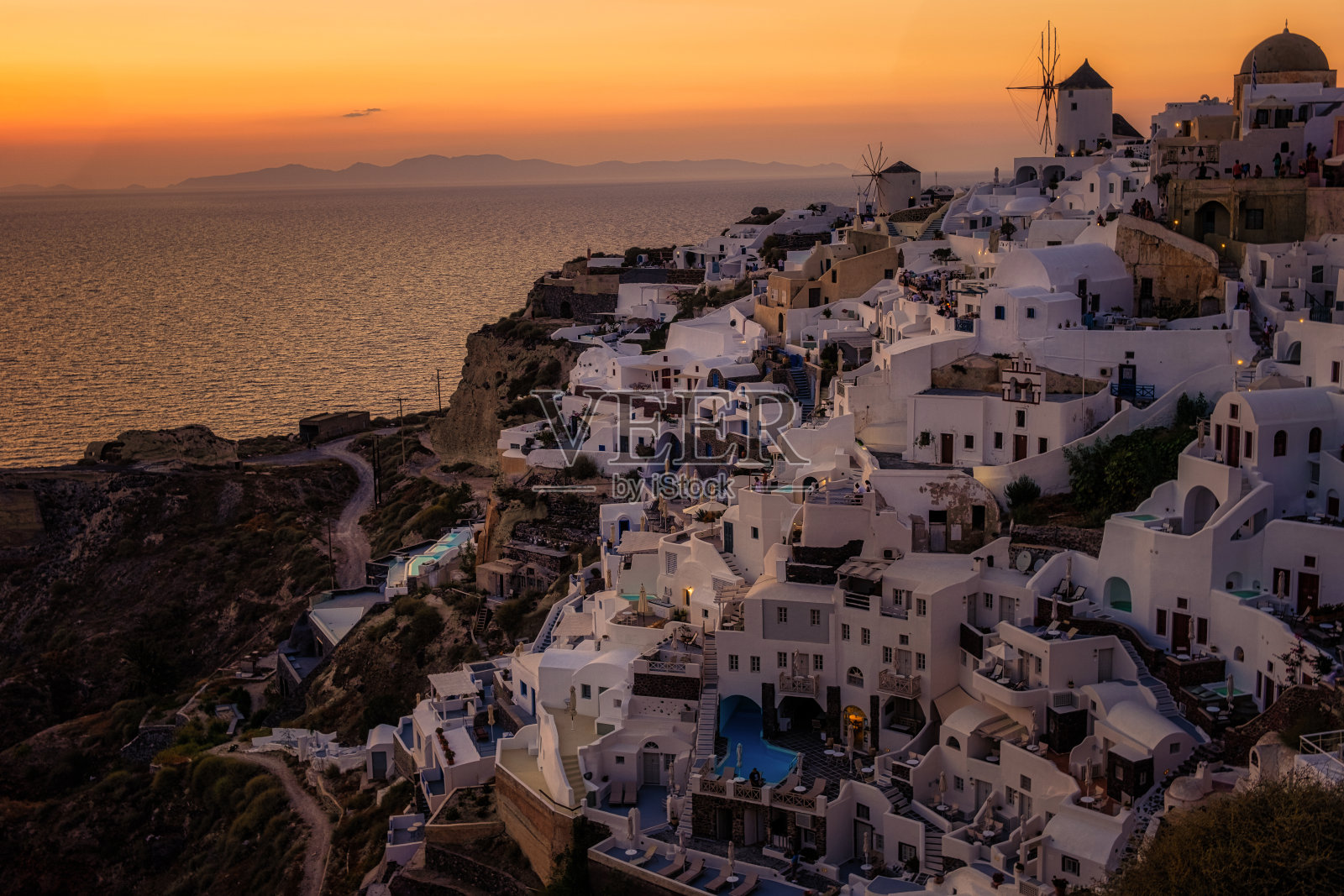 日落时分，希腊圣托里尼岛的伊亚村，蓝色的圆顶和白色的房子照片摄影图片