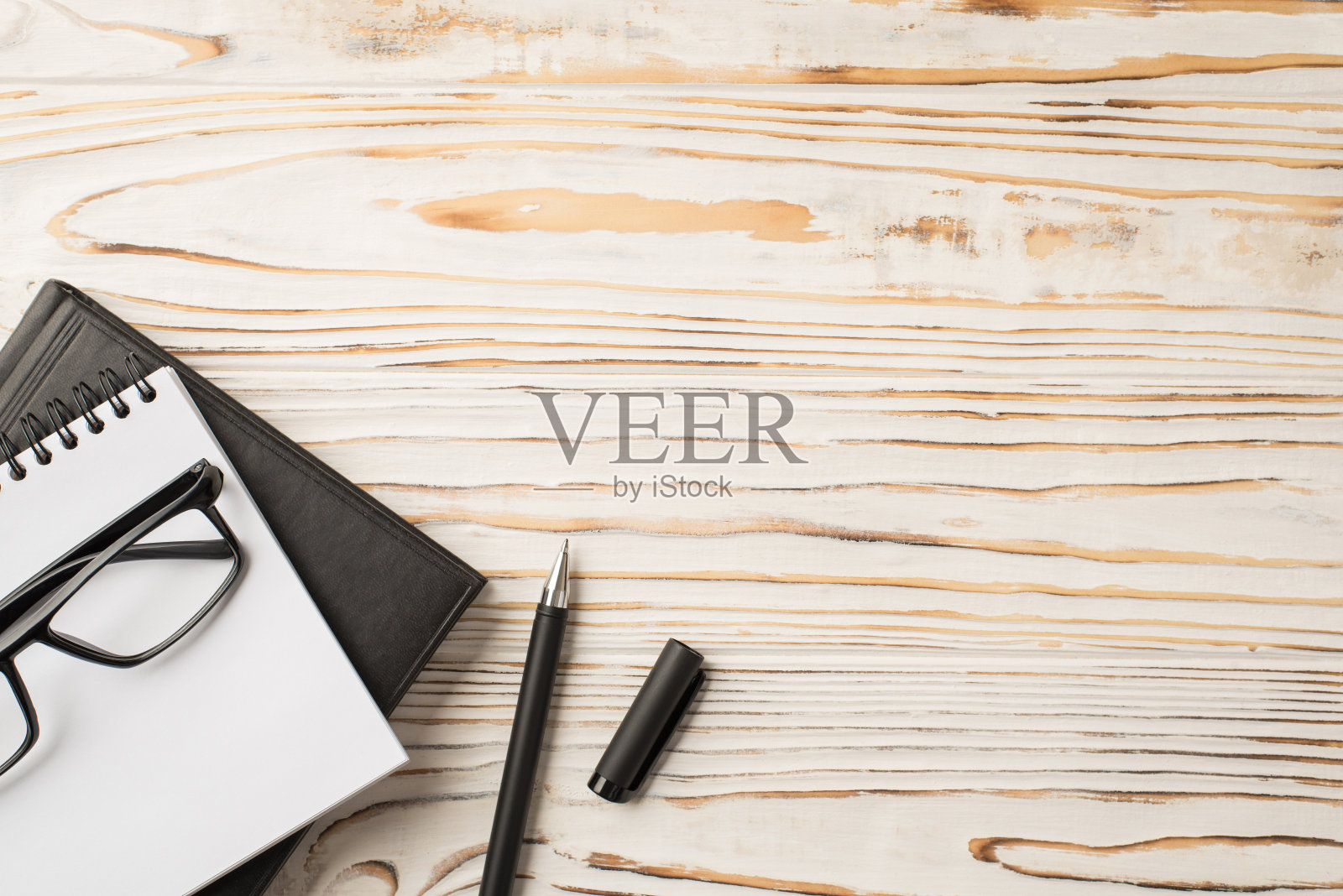 上面的照片是放在木桌上的笔记本文件夹和钢笔照片摄影图片