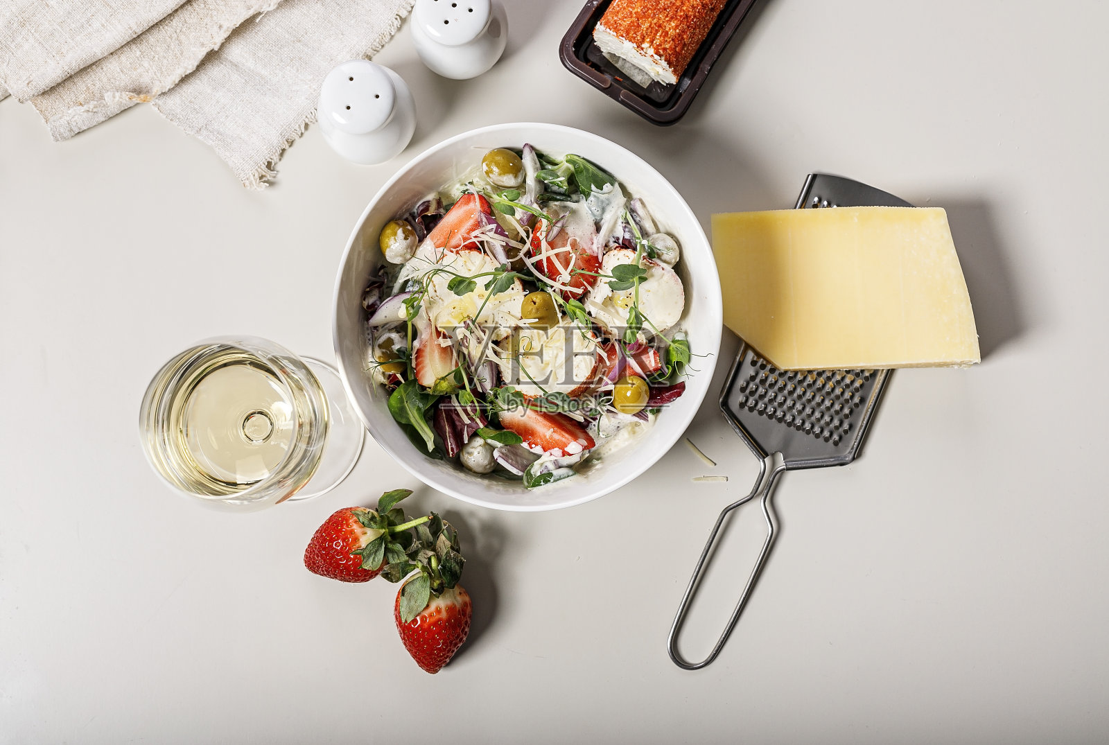 新鲜的草莓，红洋葱，香草，山羊奶酪和橄榄，美味的沙拉。光线背景下的食物静物。有机农产品。健康食品。前视图。本空间照片摄影图片