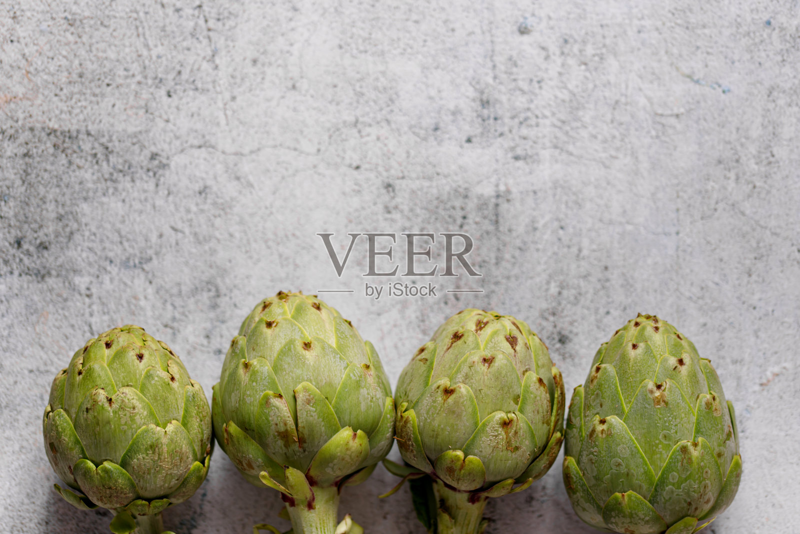 灰色背景上的洋蓟。新鲜有机洋蓟花照片摄影图片