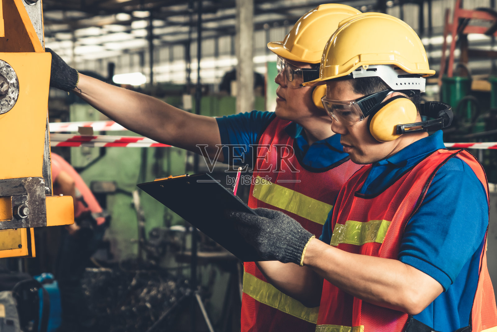 一群熟练的工厂工人在车间使用机器设备照片摄影图片