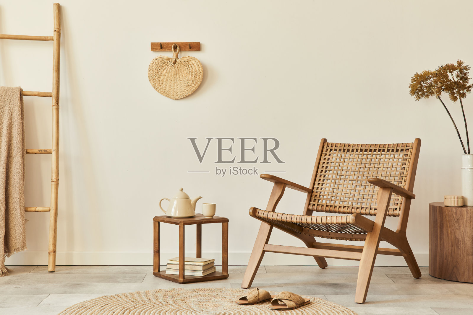 时尚的客厅室内设计与木扶手椅、茶几、家具、藤条装饰、干花和优雅的个人饰品。复制空间白墙。模板。照片摄影图片