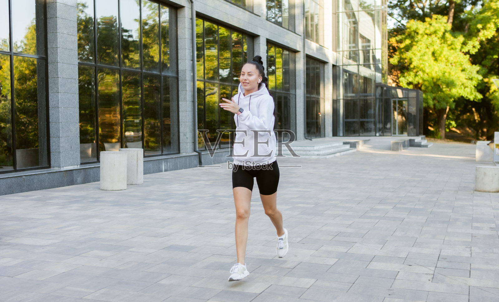 迷人的年轻健康的女人穿着白色运动帽衫慢跑户外在日出照片摄影图片