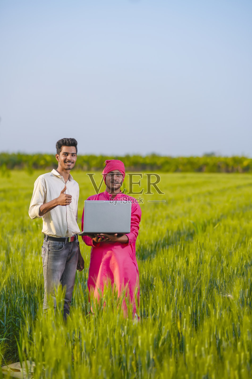 年轻的印度农学家和农民使用笔记本电脑看一些有关农业的信息照片摄影图片