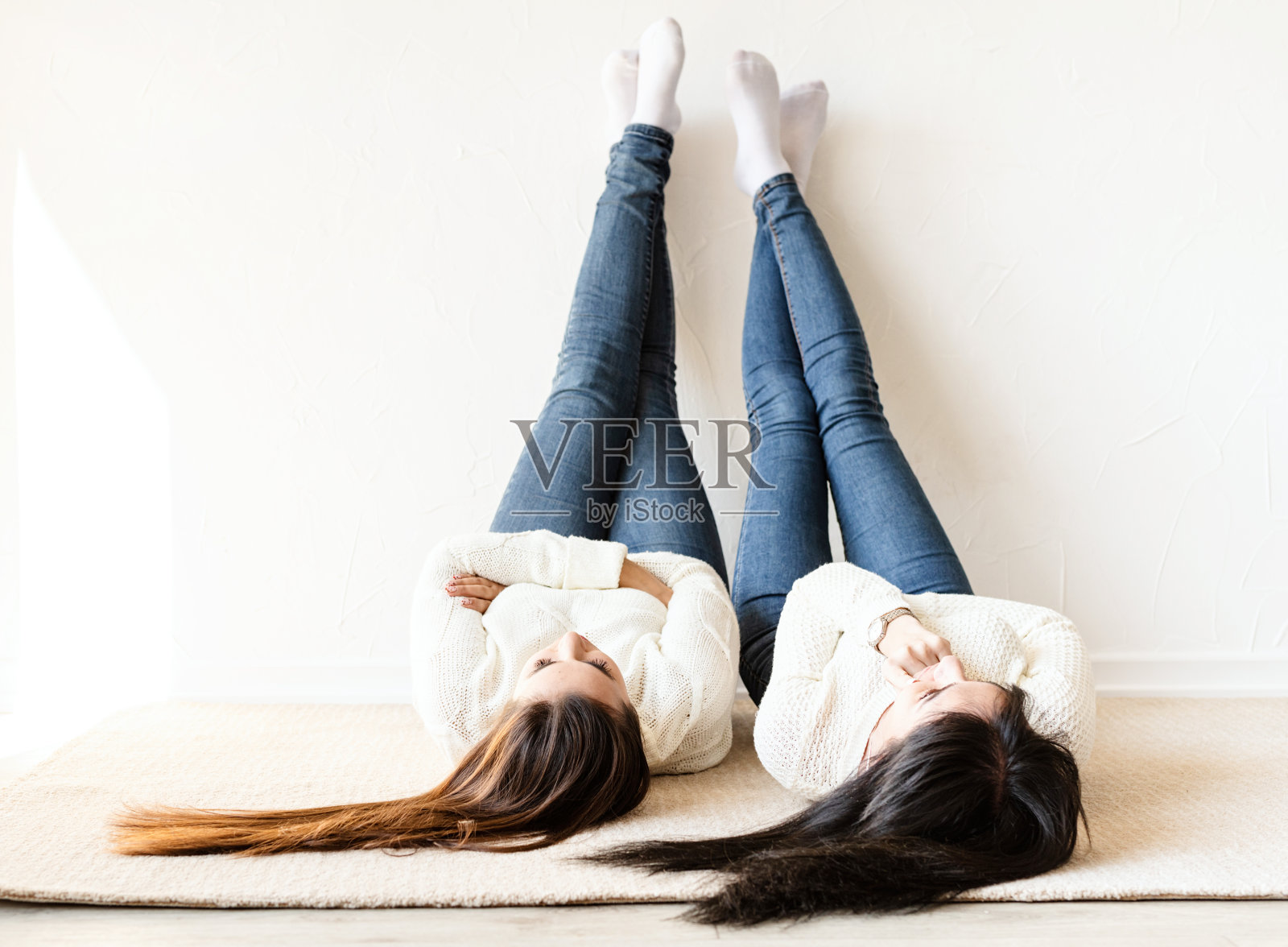 两个女人躺在地毯上玩得很开心照片摄影图片