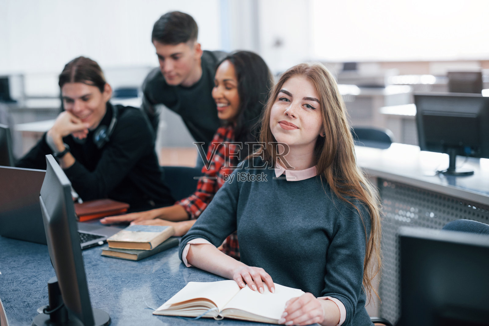 美好的阳光。一群年轻人穿着休闲装在现代化的办公室里工作照片摄影图片