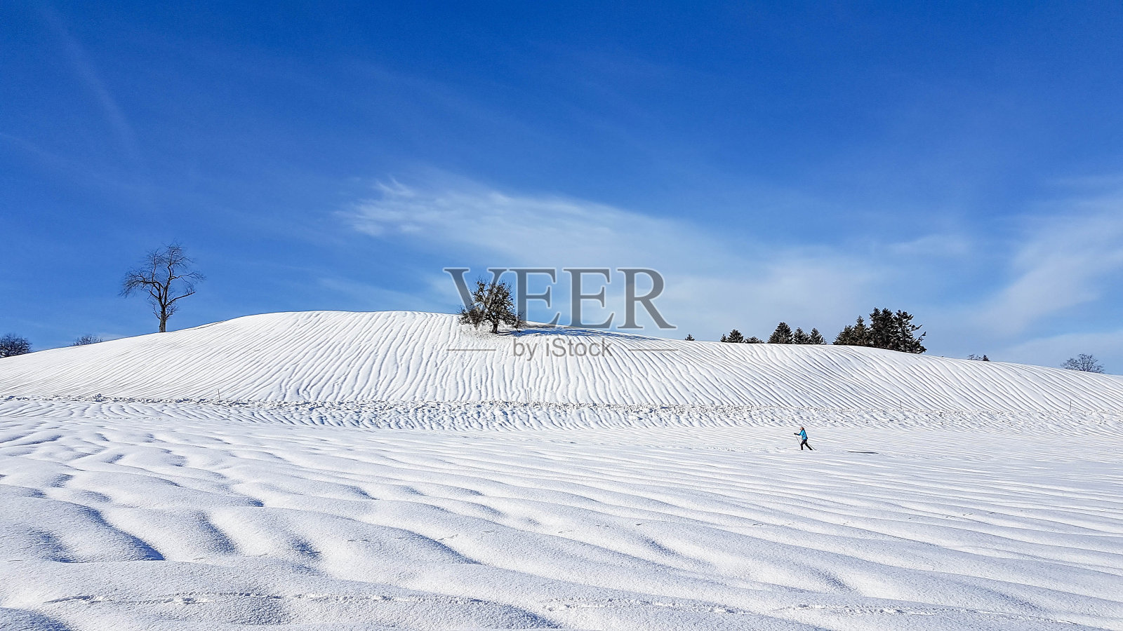 孤独的越野滑雪者在冬季景观与水沟的雪照片摄影图片