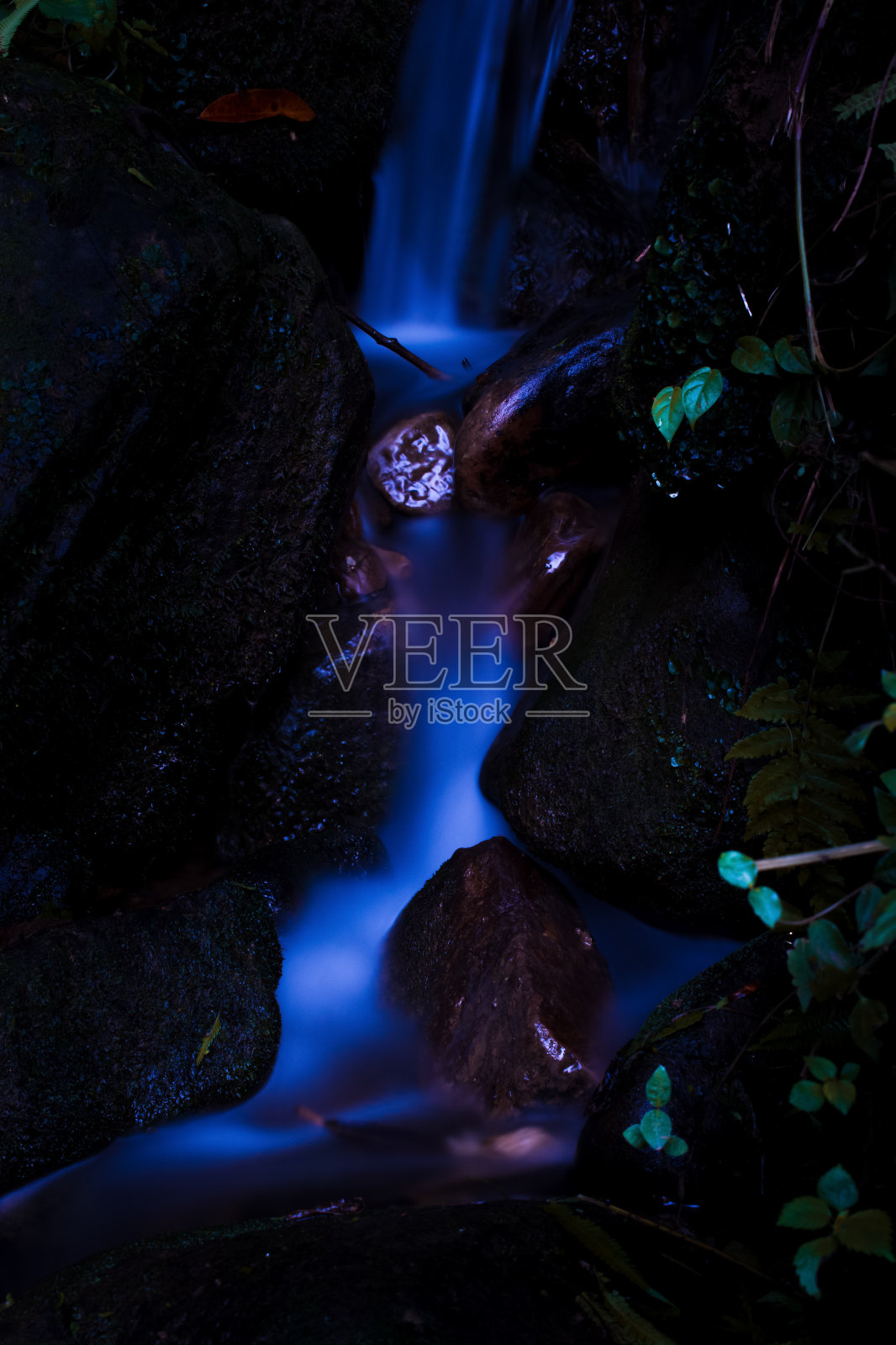 长时间曝光的小瀑布照片看起来就像一泓发光的水。照片摄影图片