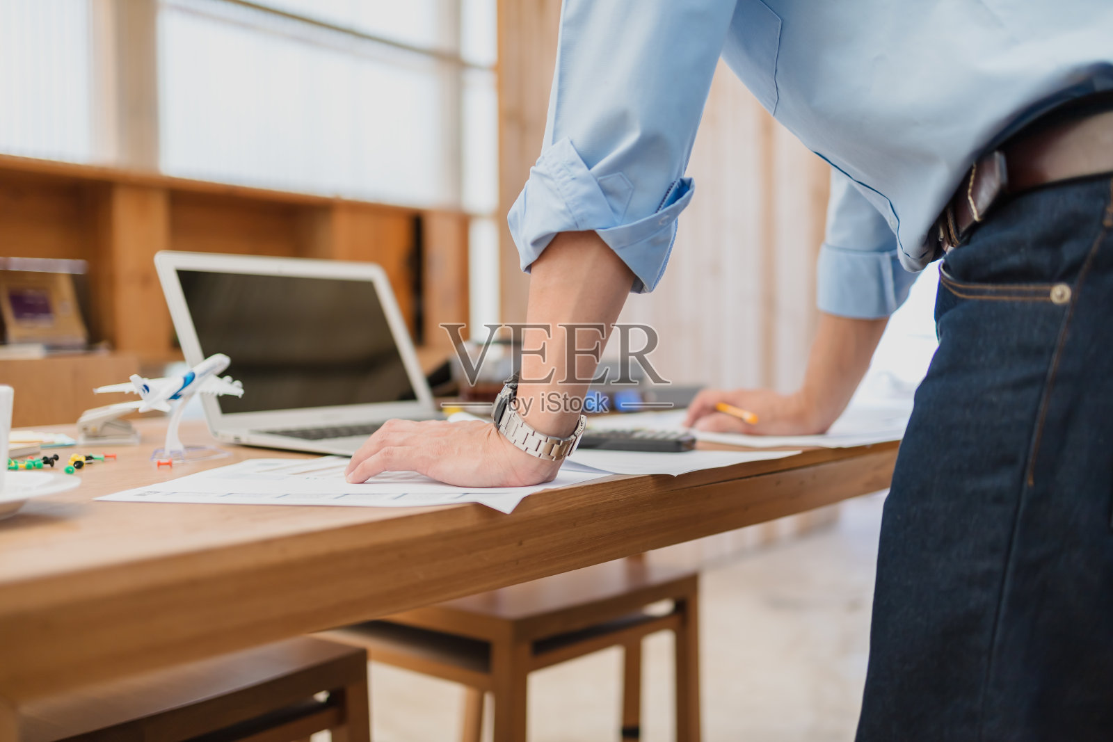 商人站起来，阅读纸质图表和检查文件数据计算器计算预算会计。财务会计概念。照片摄影图片