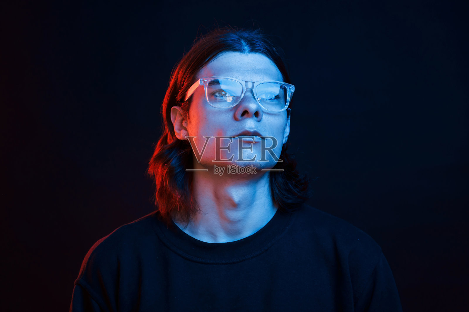 未来的观念。工作室拍摄在黑暗的工作室与霓虹灯。严肃男人的肖像照片摄影图片