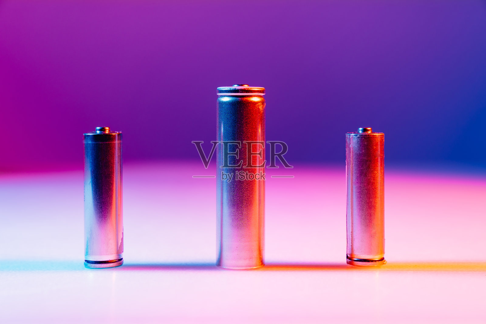 AA和8650锂离子银电池在多色光照射下照片摄影图片