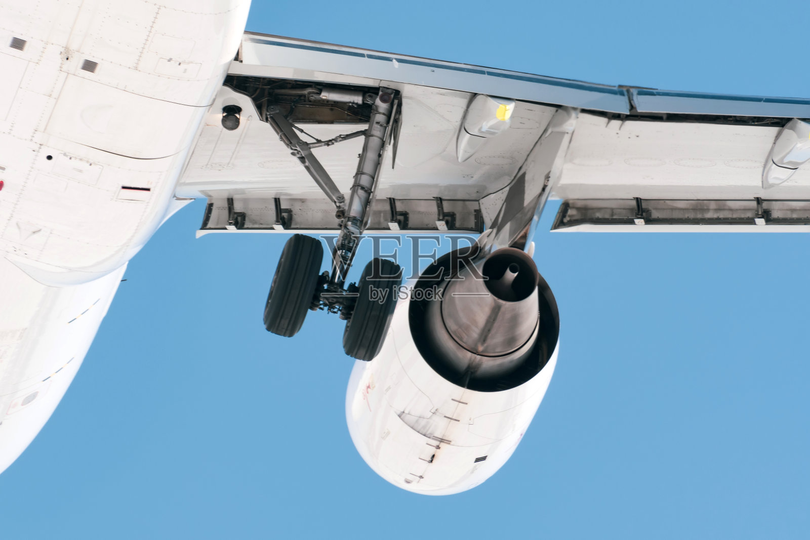 喷气式发动机和起落架在空中飞行，后视图。照片摄影图片