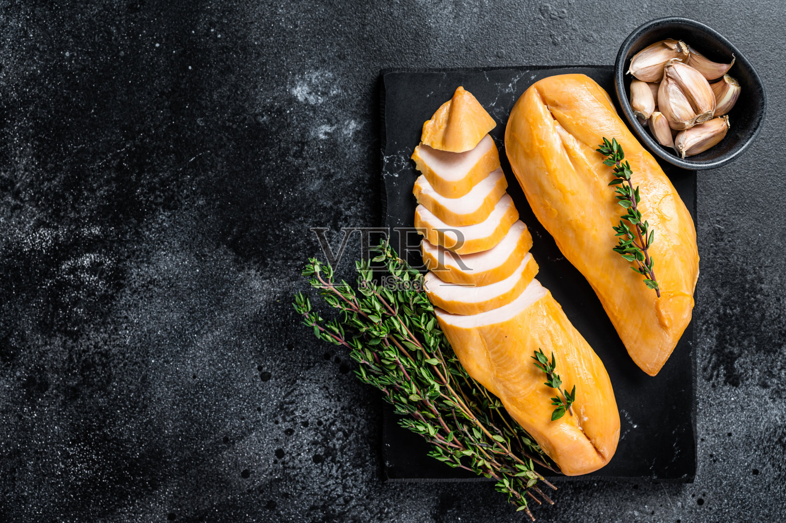 烟熏切鸡胸肉美味。黑色背景。前视图。本空间照片摄影图片