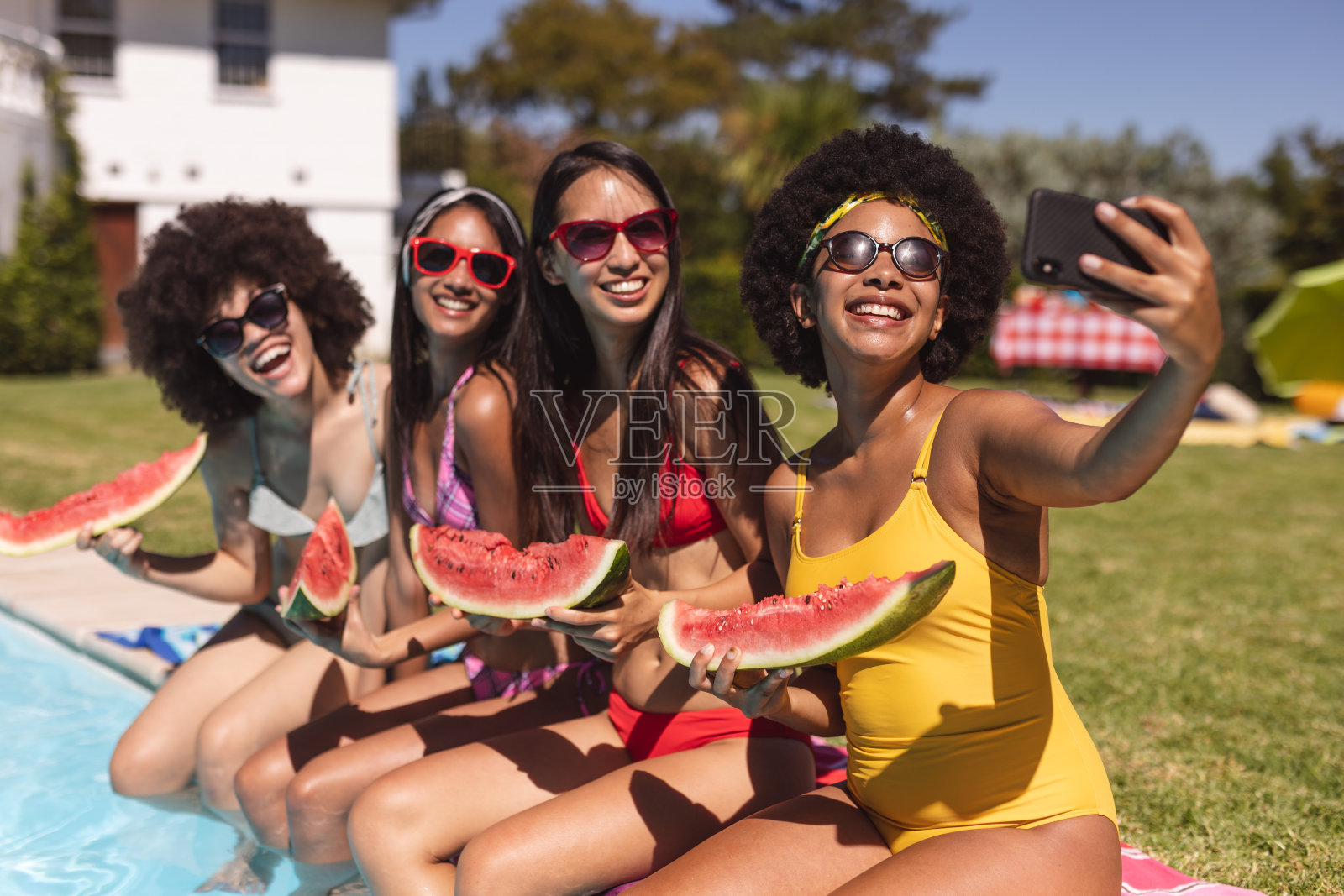 一群不同的女性朋友在泳池边和西瓜自拍照片摄影图片