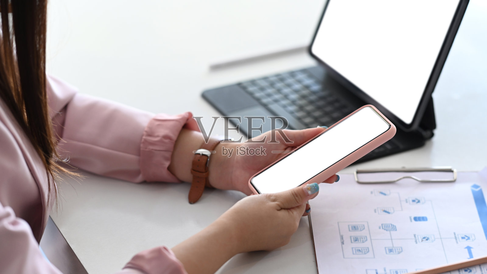 女商人坐在办公桌前用平板电脑和手机工作。照片摄影图片