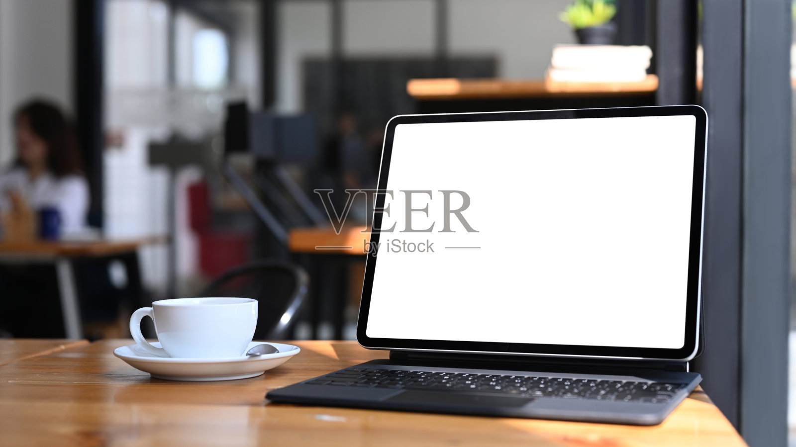 近距离观看电脑平板与空屏幕和咖啡杯在木桌上。照片摄影图片