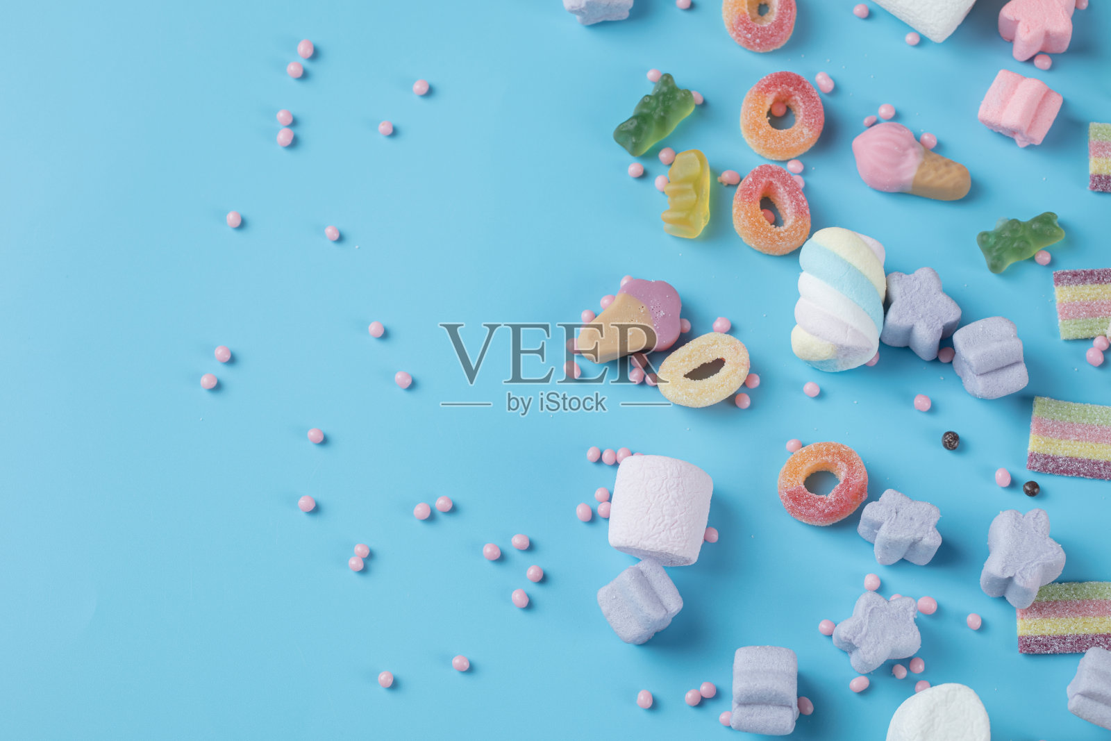 软糖和棉花糖混合在蓝色的背景上照片摄影图片