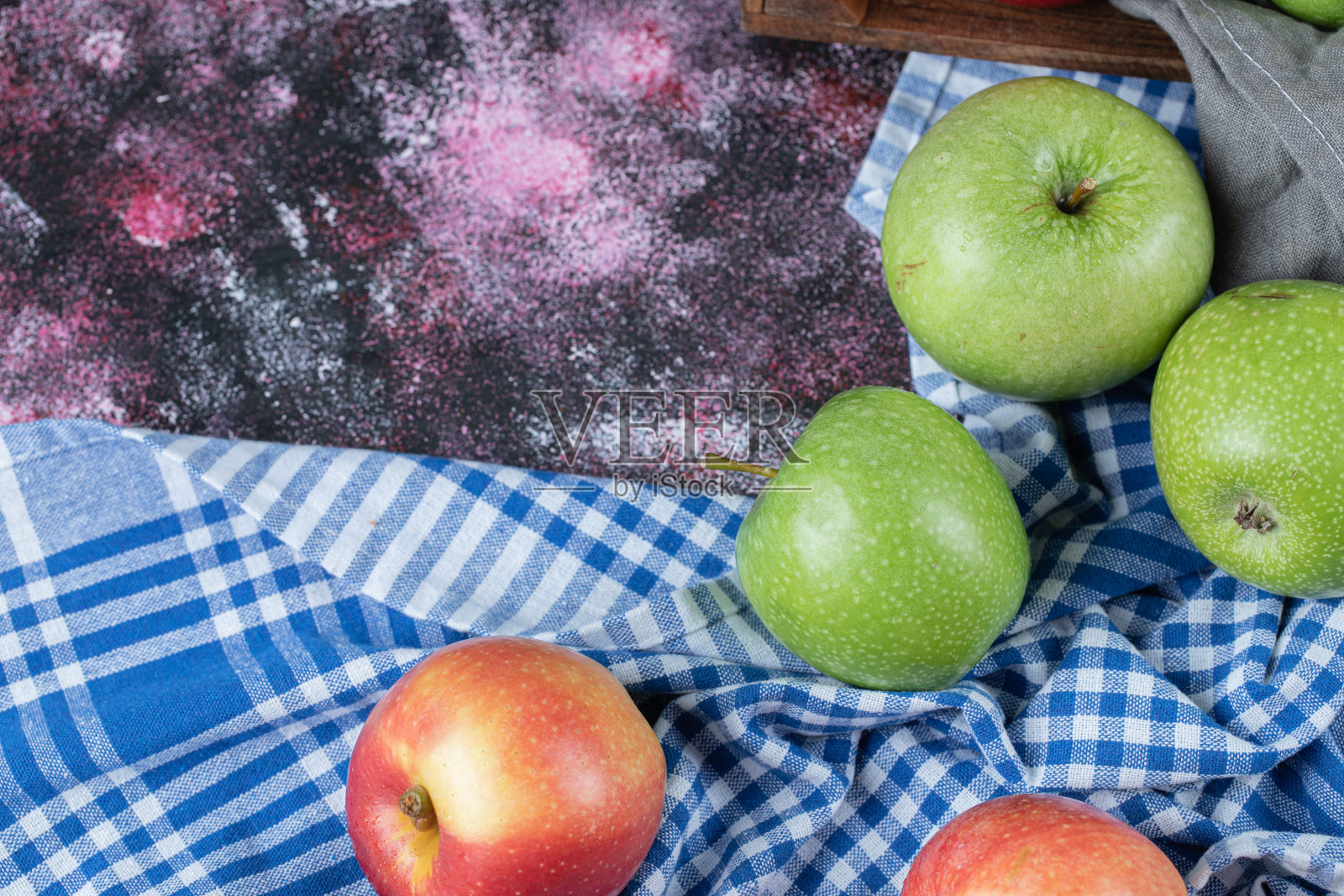 蓝格子的厨房毛巾上印着红绿苹果照片摄影图片