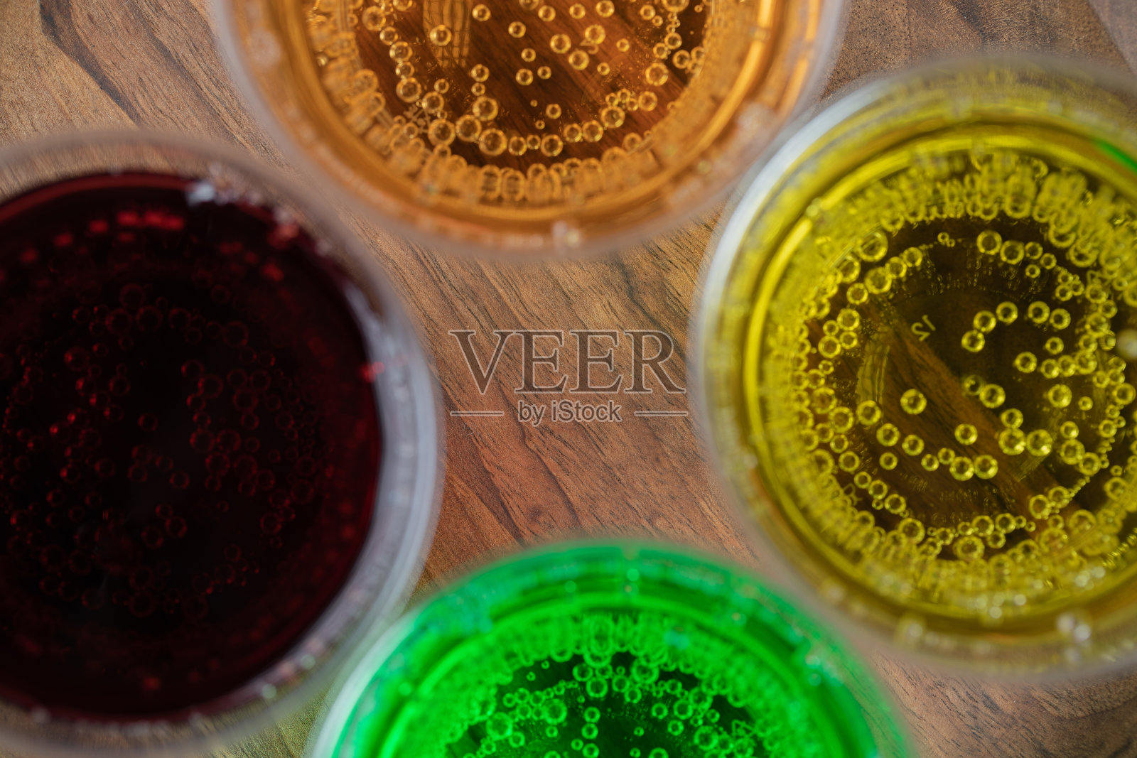 彩色饮料装在塑料杯里，放在木盘子里照片摄影图片