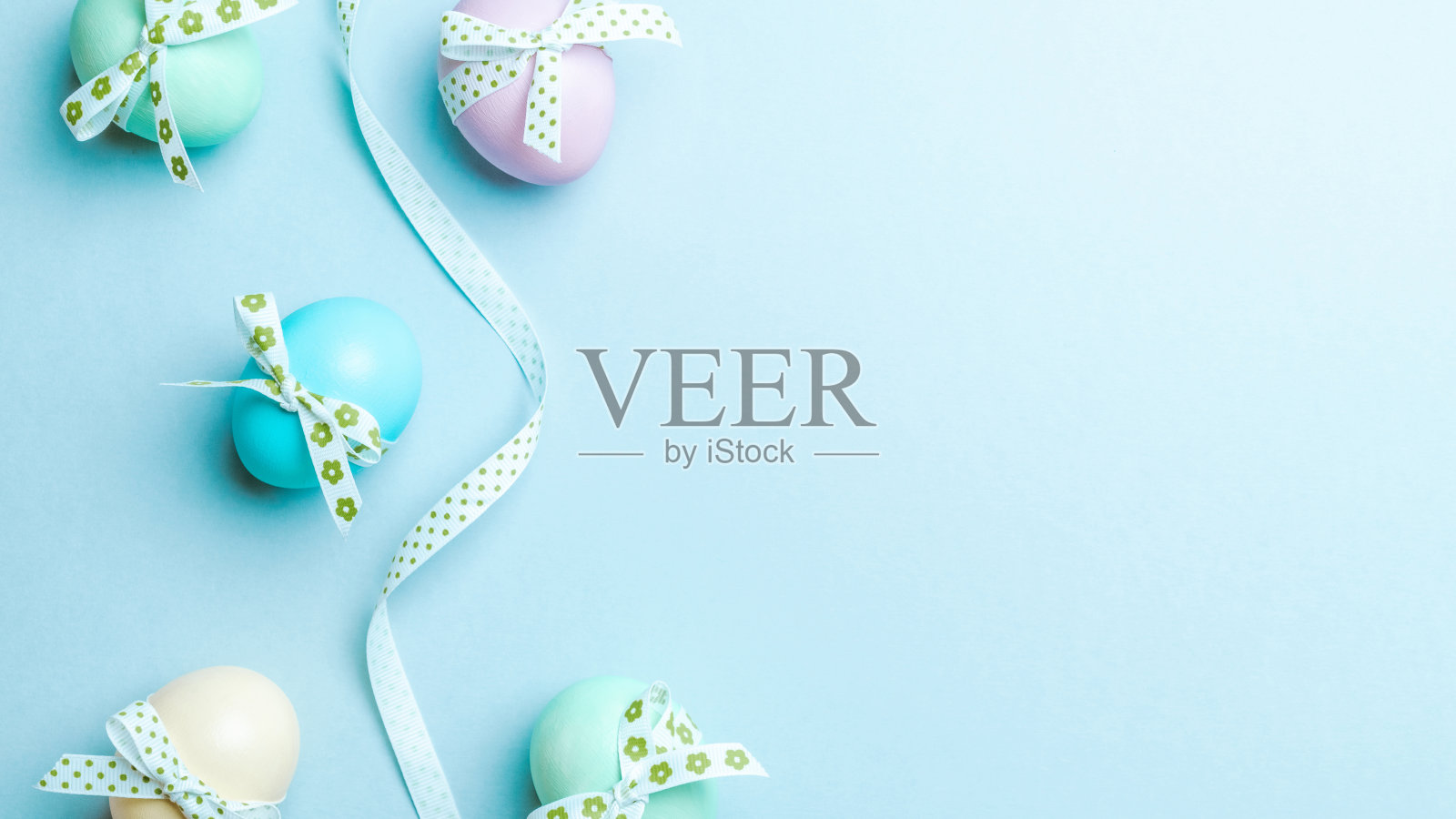 复活节的奢侈品。彩色彩蛋与彩带在彩色的蓝色背景在快乐复活节装饰。平躺，俯视图。照片摄影图片