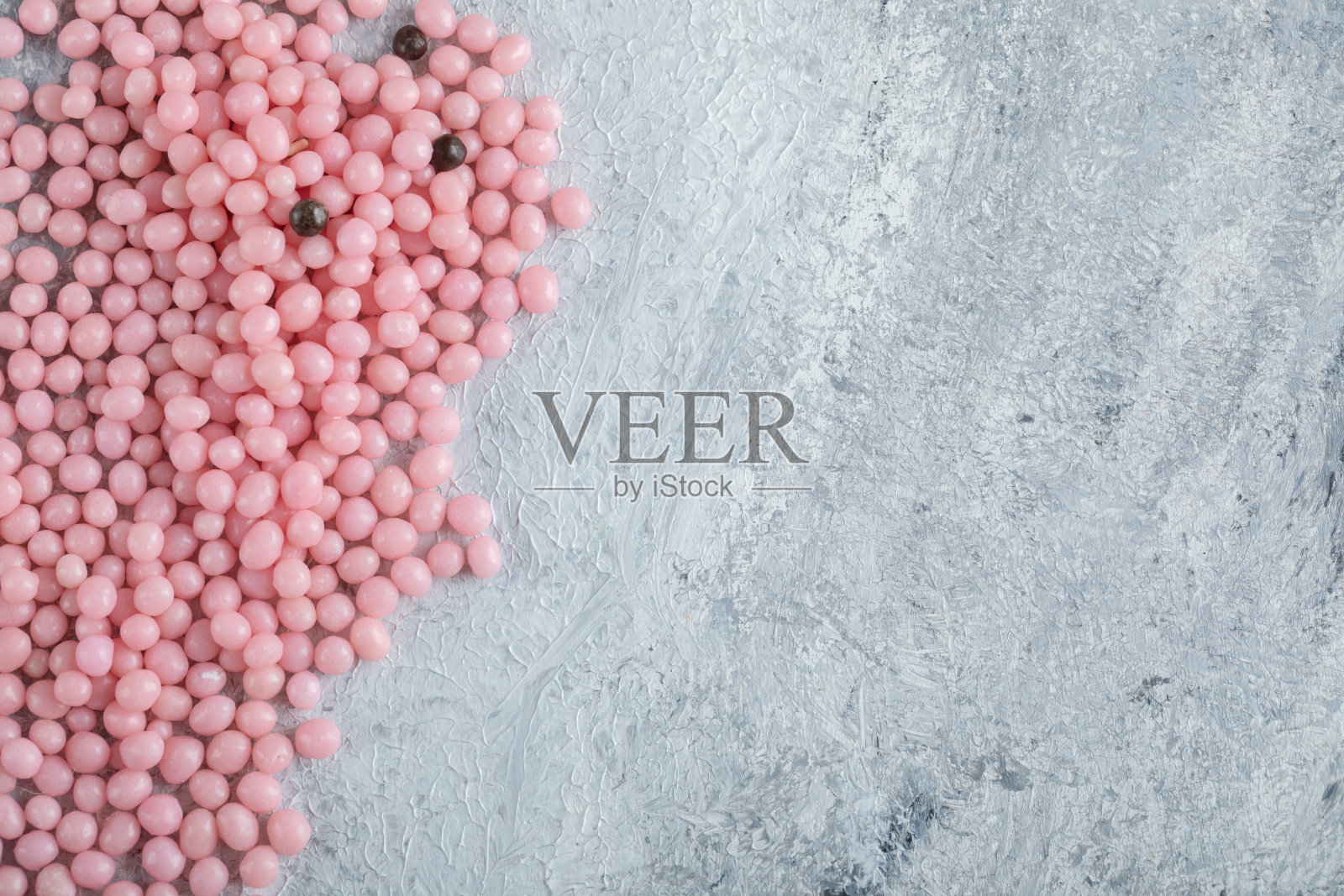 大理石背景上的一堆粉色糖果照片摄影图片