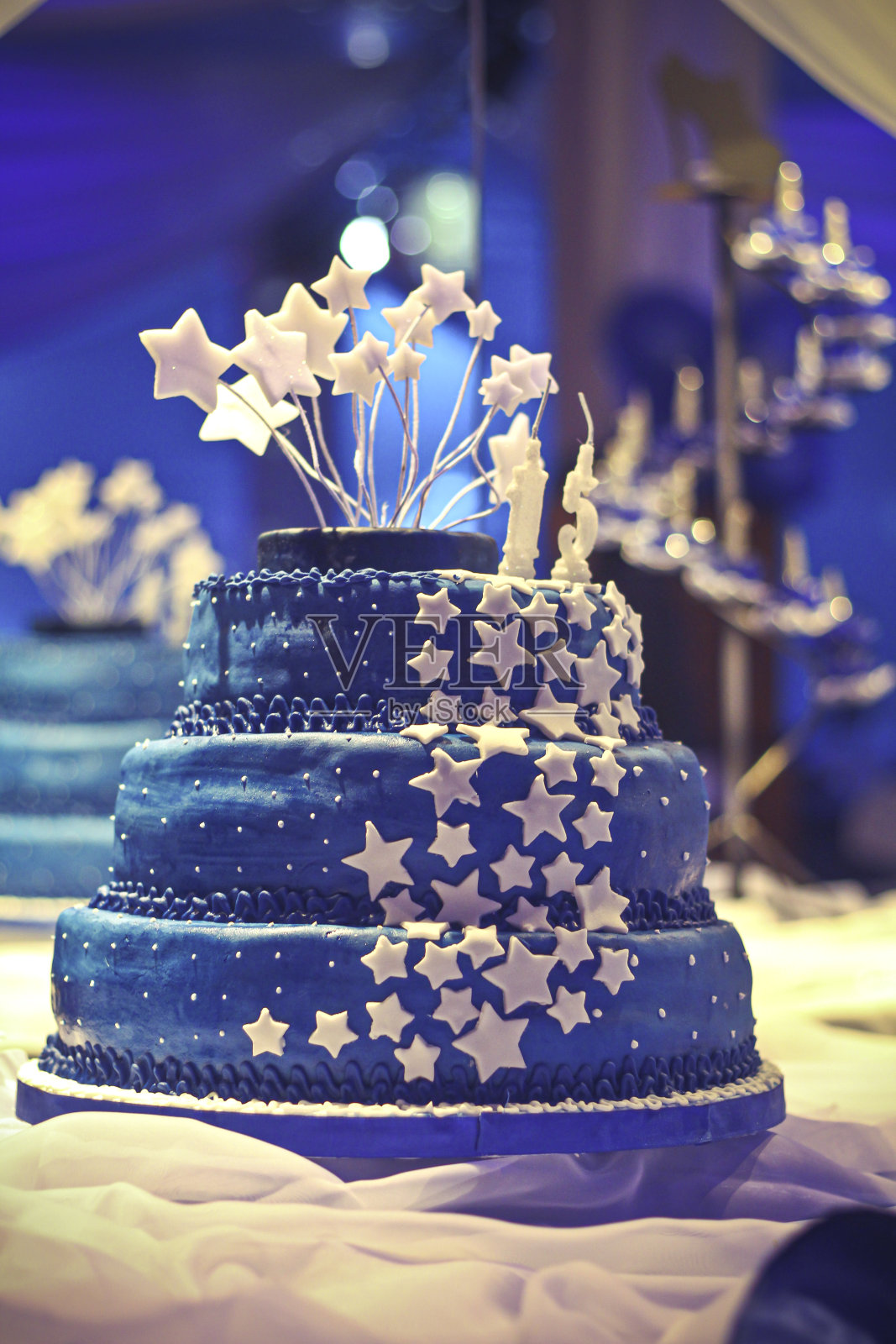 美丽和巨大的生日蛋糕装饰在一个多功能厅。照片摄影图片