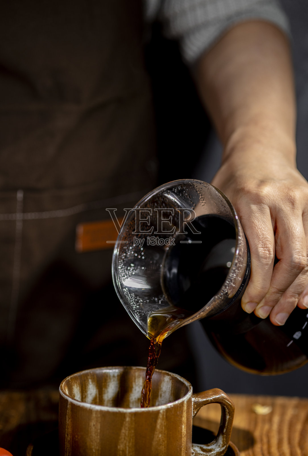 用手把咖啡倒到咖啡杯里照片摄影图片