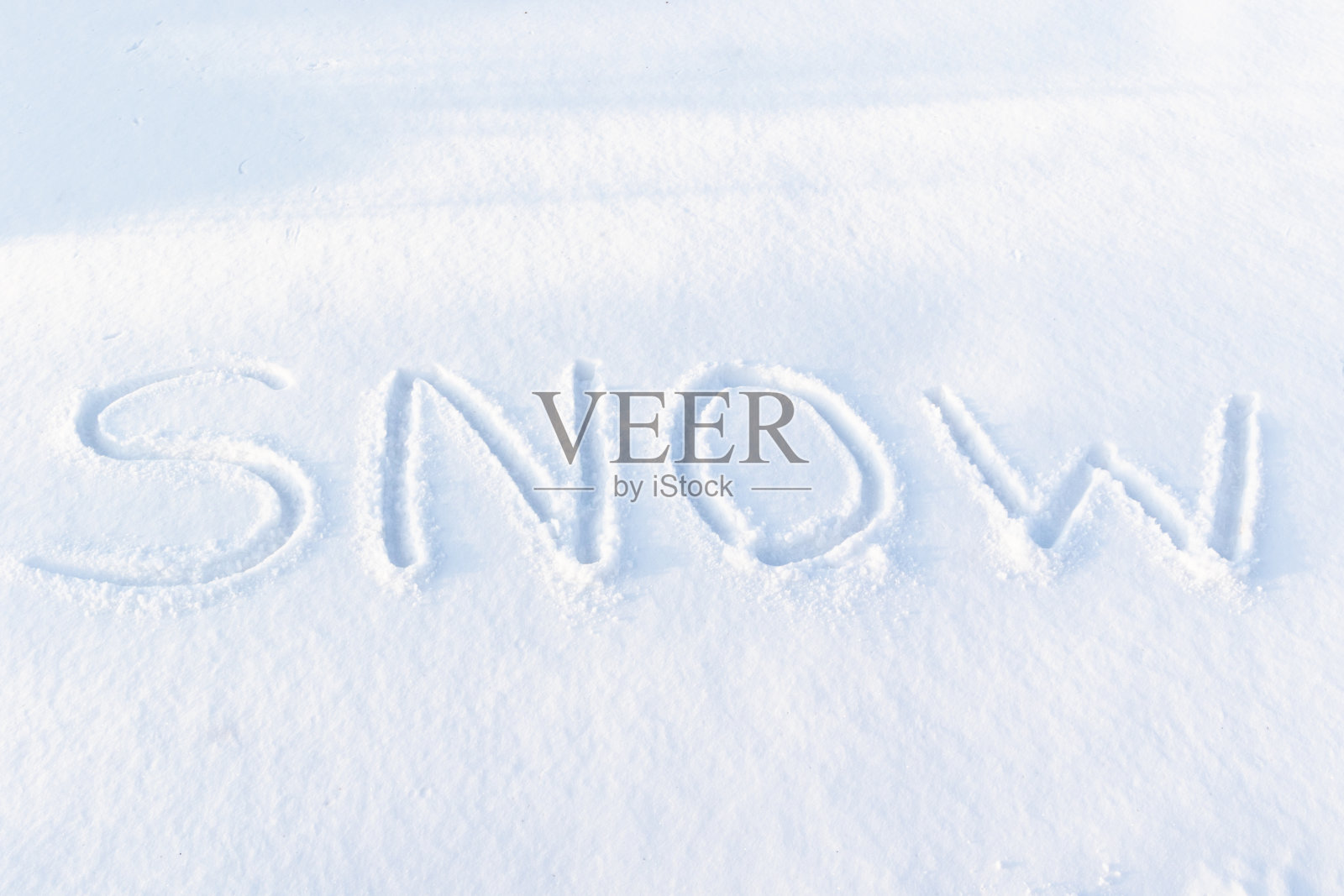 在一个寒冷的冬日阳光明媚的日子，在纯净的白雪上刻下铭文。特写镜头照片摄影图片