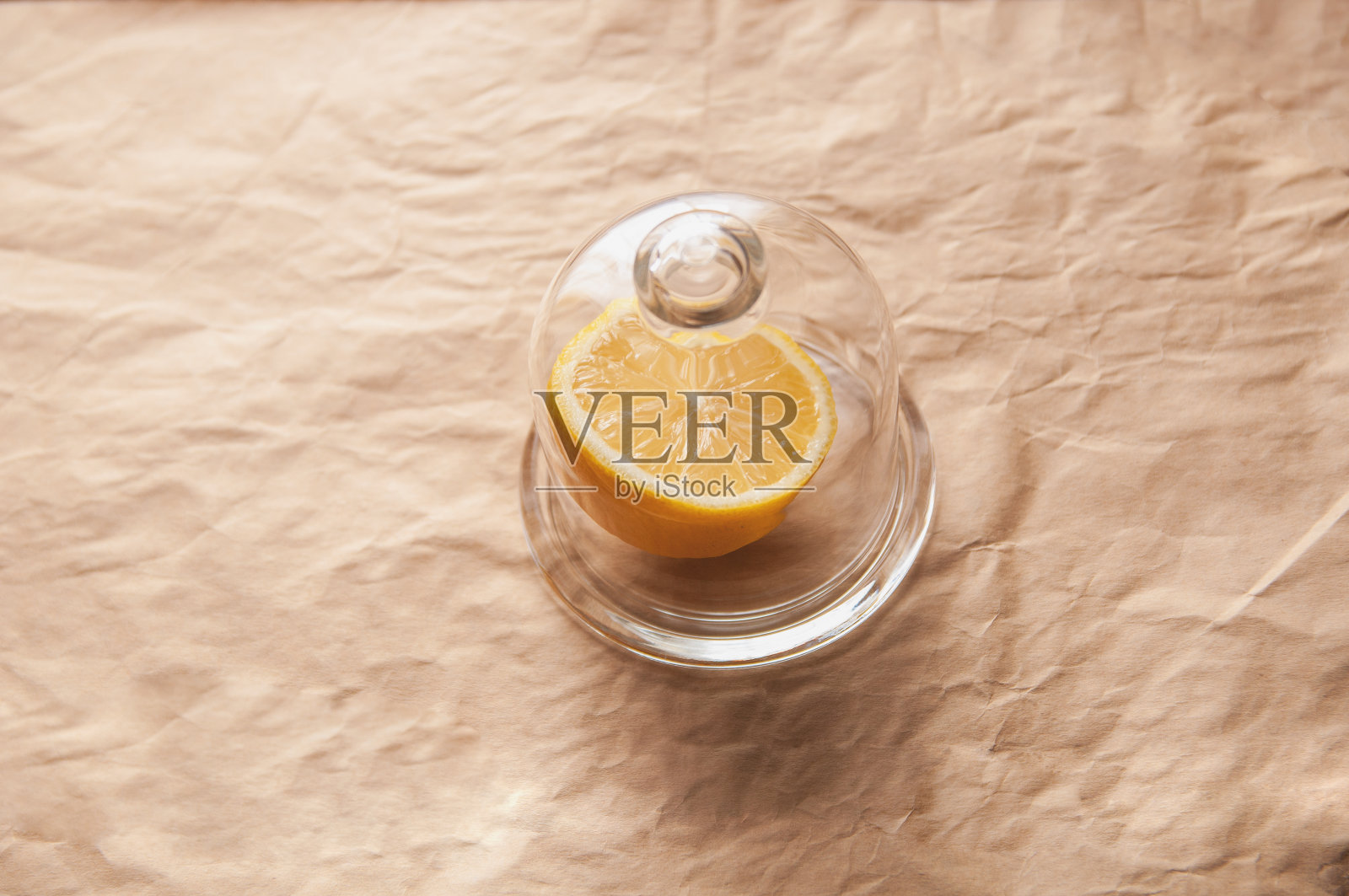 柠檬的一部分放在一杯柠檬草上，盖上牛皮纸作为背景照片摄影图片