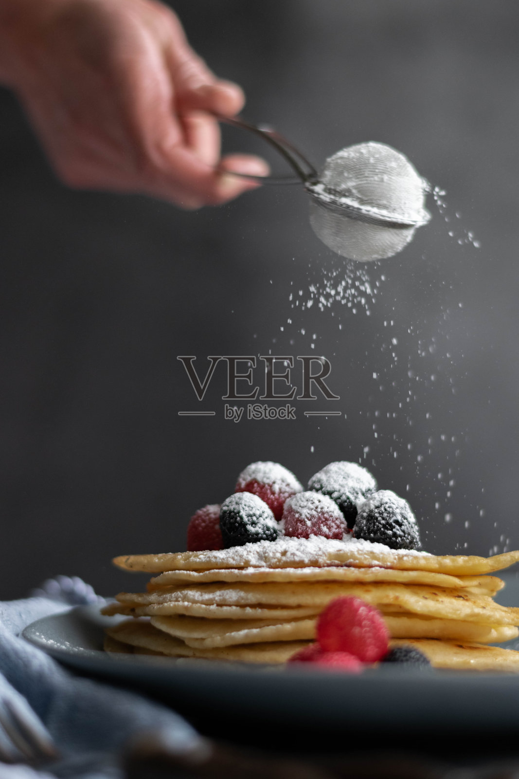 把糖倒在桌上自制的薄饼上，深色食物摄影照片摄影图片