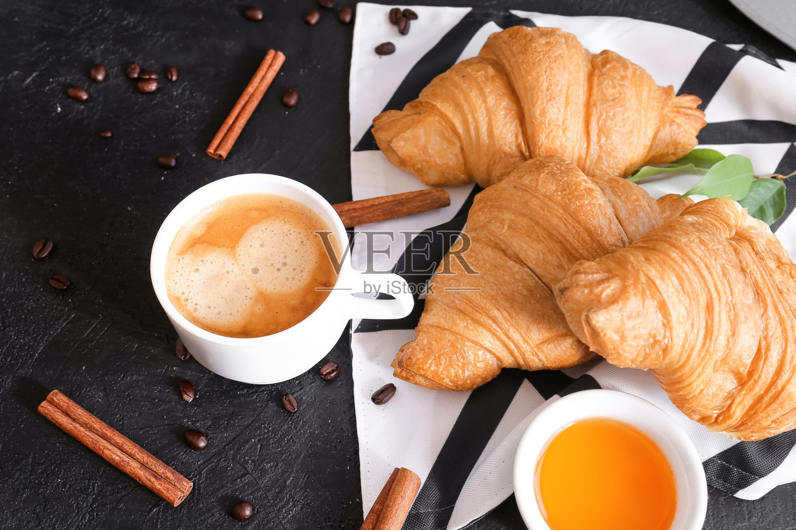 牛角面包和咖啡在深色的背景上照片摄影图片