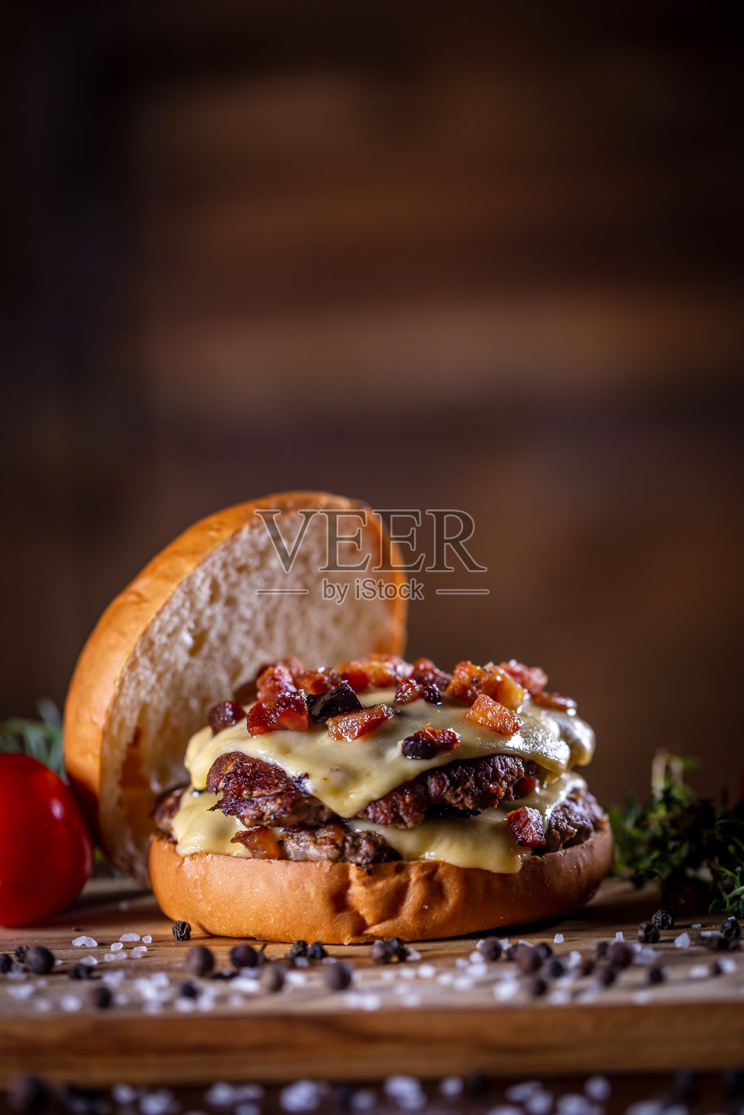 手工牛肉碎汉堡与奶酪，培根和酱汁在木制的背景照片摄影图片