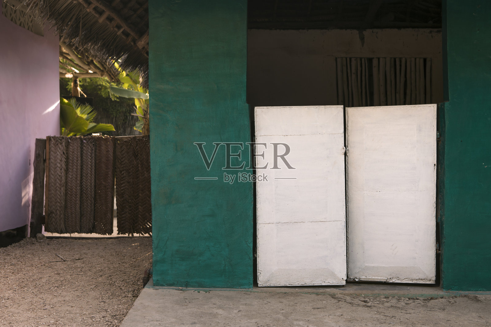 神秘的热带花园入口。色彩缤纷的度假海滨别墅正面。桑给巴尔岛风景如画的乡村建筑。照片摄影图片