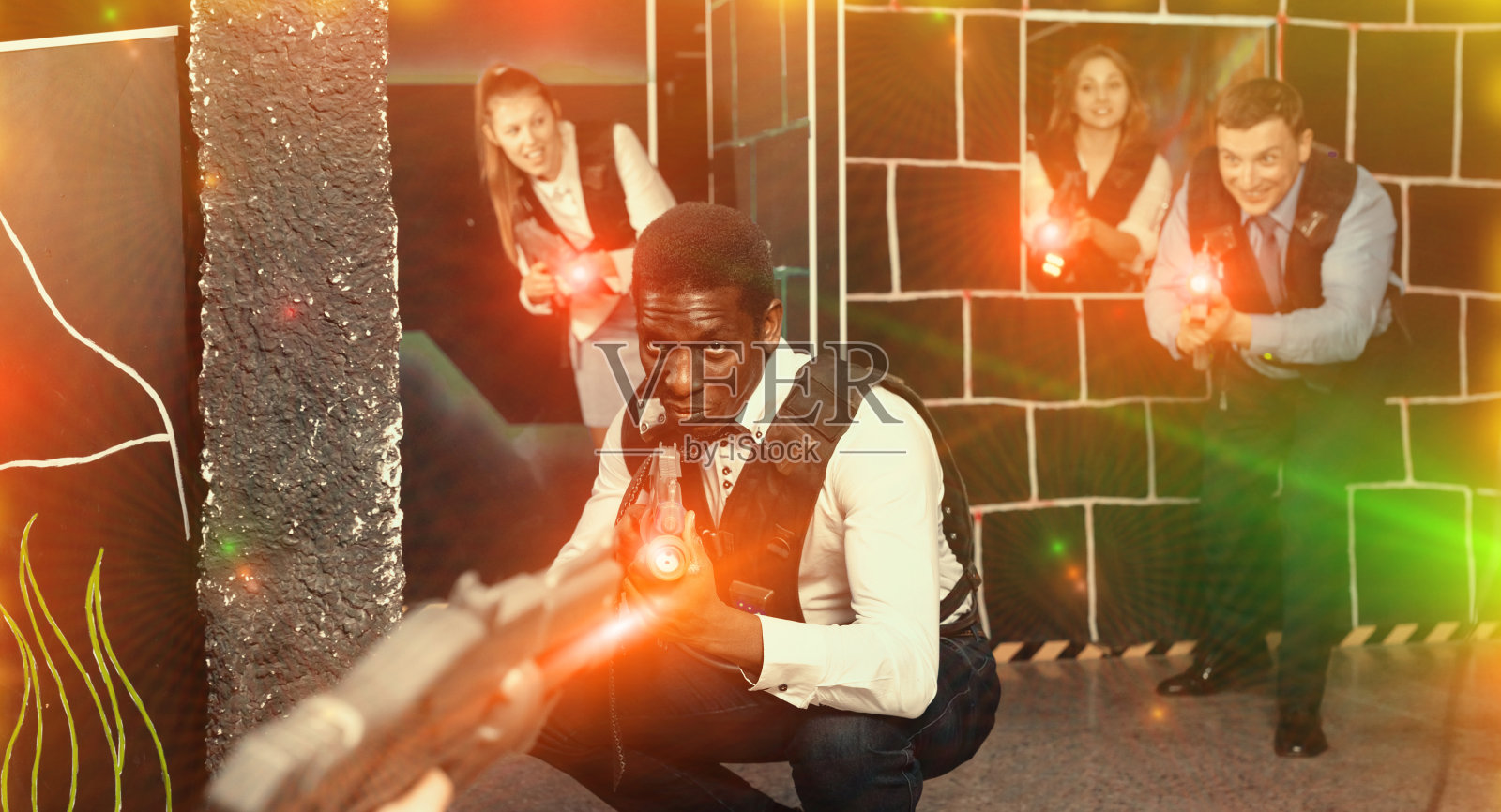 一群同事拿着激光手枪玩激光枪战游戏照片摄影图片