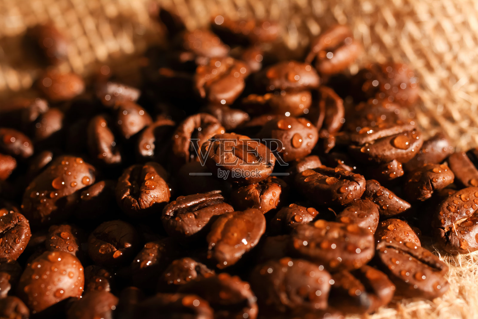 宏观特写堆新鲜烤有机咖啡豆在黄麻织物袋照片摄影图片