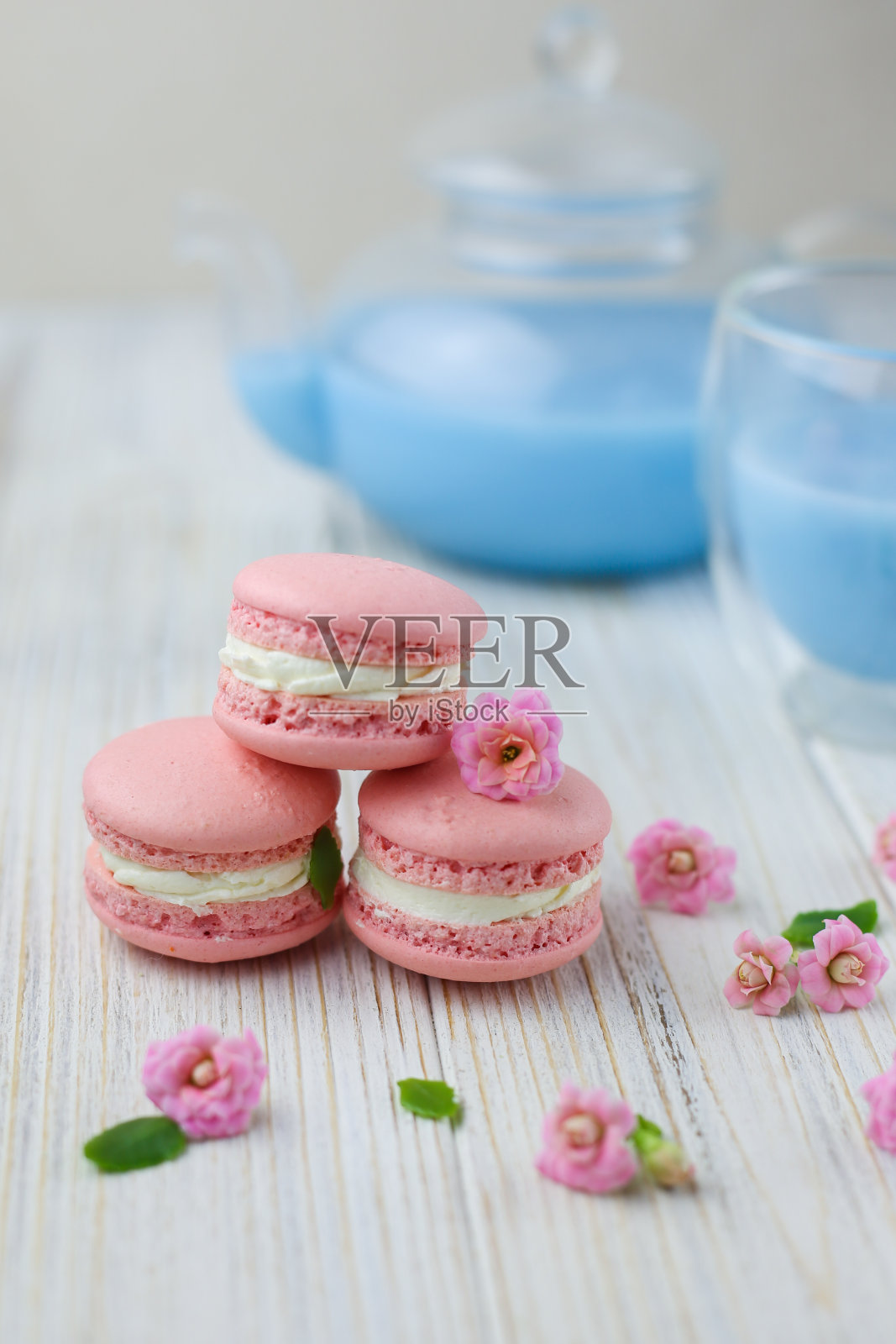 粉色的蛋白杏仁饼干和一壶蓝色的马沙拉茶照片摄影图片