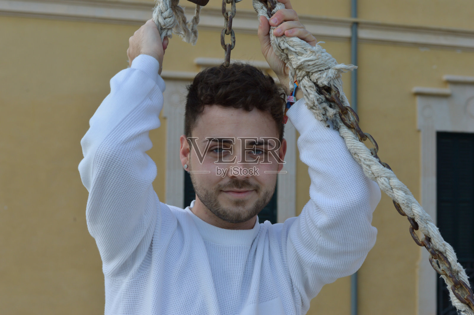 一个留着胡子拿着绳子的英俊年轻人的肖像照片摄影图片