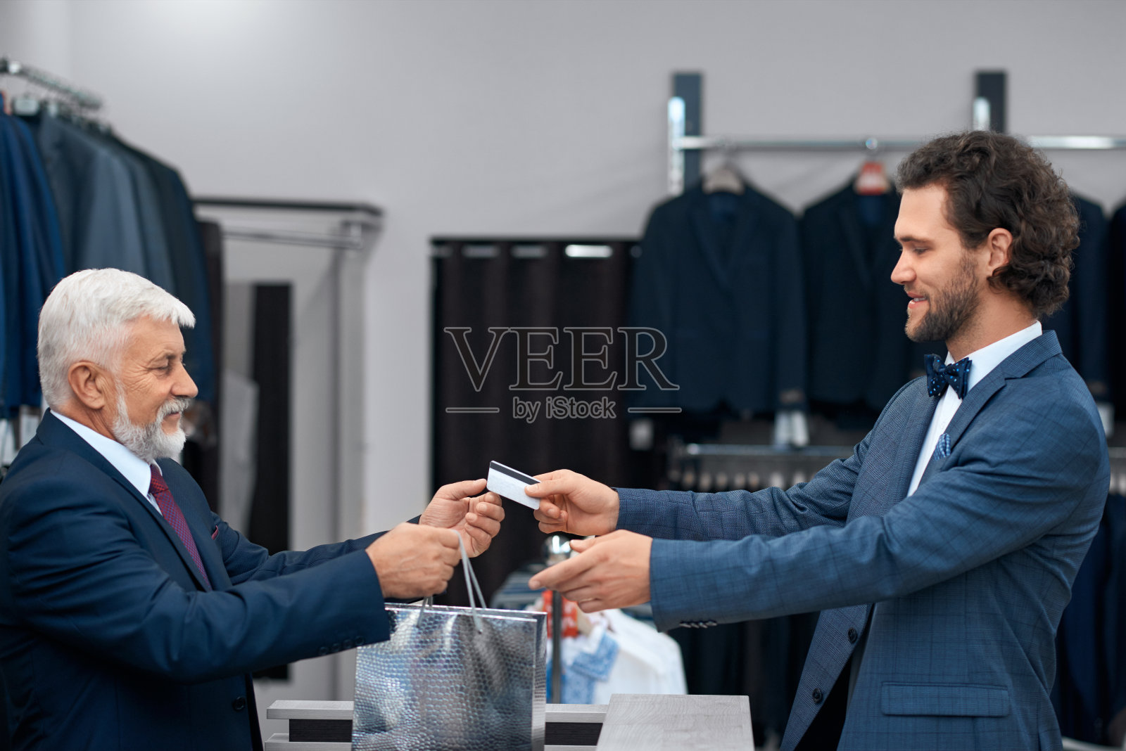 年轻人在购物，并给信用卡。照片摄影图片