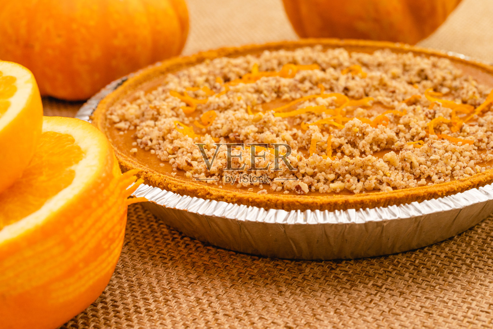 新鲜烘焙的自制南瓜派装饰碎坚果和橙色皮屑近距离乡村背景，选择性的焦点照片摄影图片
